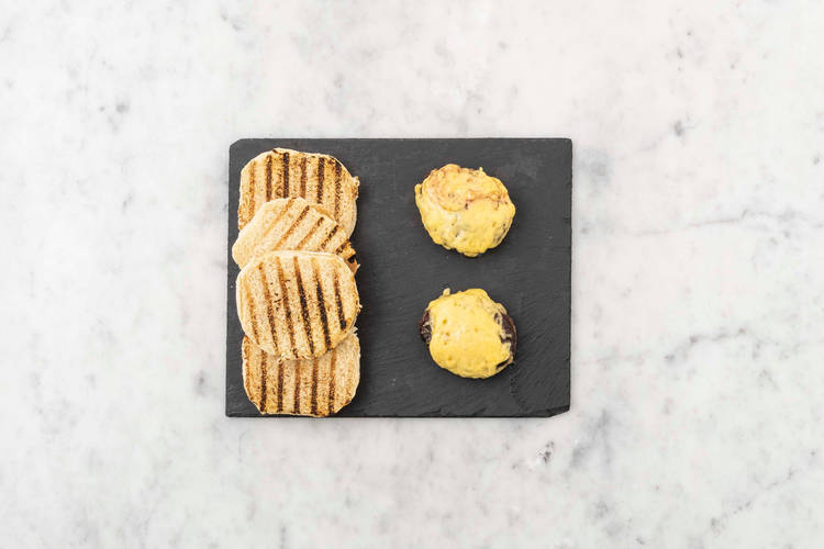 Grill buns and melt cheese