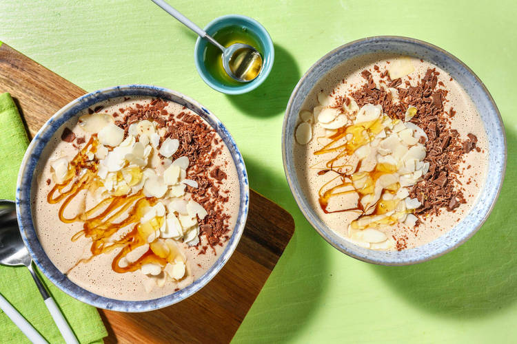 Smoothie à la banane & beurre de cacahuète préparé avec du lait, des amandes effilées et copeaux de chocolat