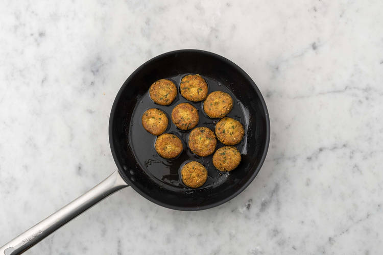 Cuocere i falafel e scaldare i naan