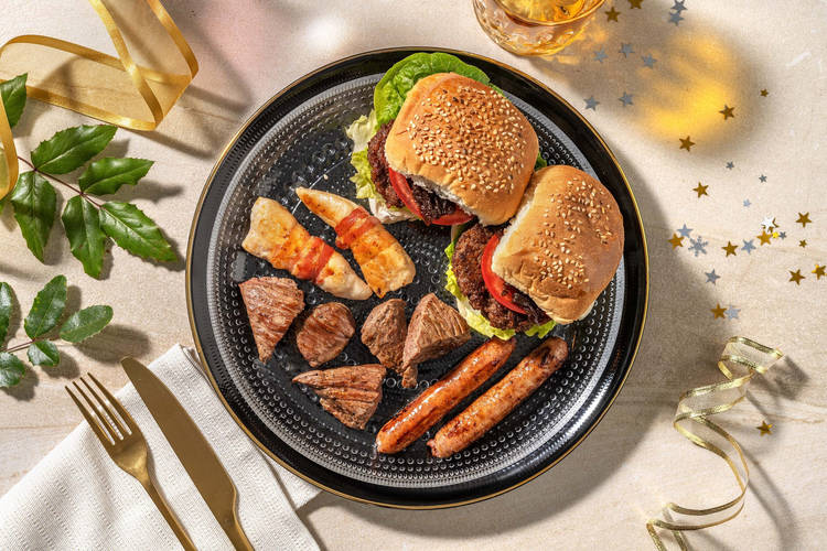 Vlees- en gevogeltekwartet met kip in spek, biefstukpuntjes, kipworstjes  en wildzwijnburgers met uitenchutney