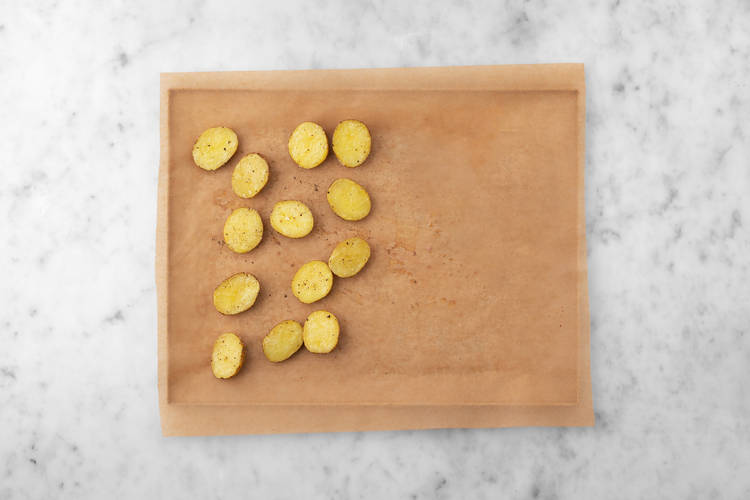 Season potatoes and sear pork