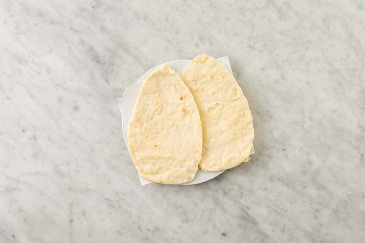 Warm flatbreads and make salad