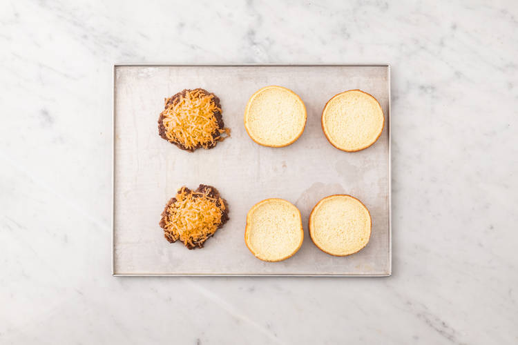 Toast buns, melt cheese and make secret sauce