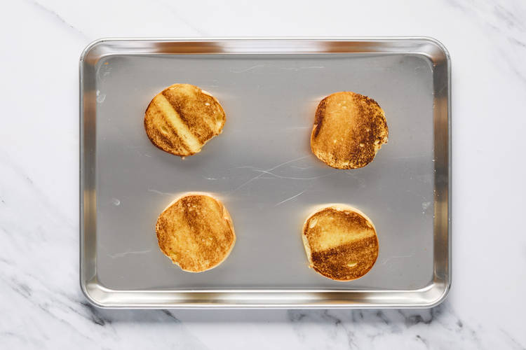 Toast buns and cook eggs