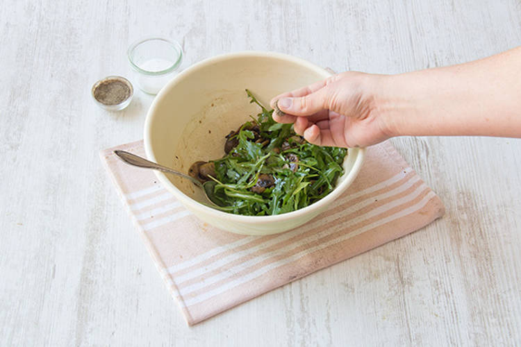 Toss the arugula into the dressing