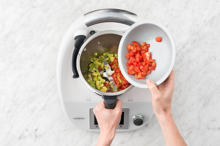 Tomatenstücke zu der Avocado geben