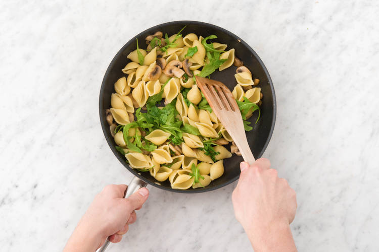 Verhit de conchiglie, champignons. Voeg daarna de rucola toe.