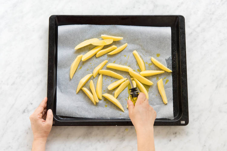 Kartoffelspalten mit Öl vermischen