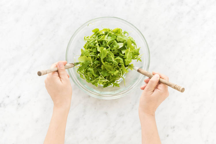In einer großen Schüssel Rucola vermischen.