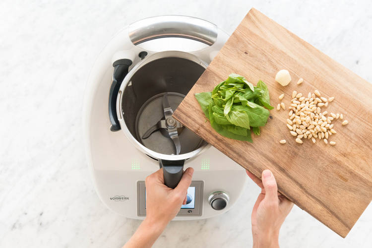 Knoblauch, Basilikum und Pinienkerne in den Mixtopf geben