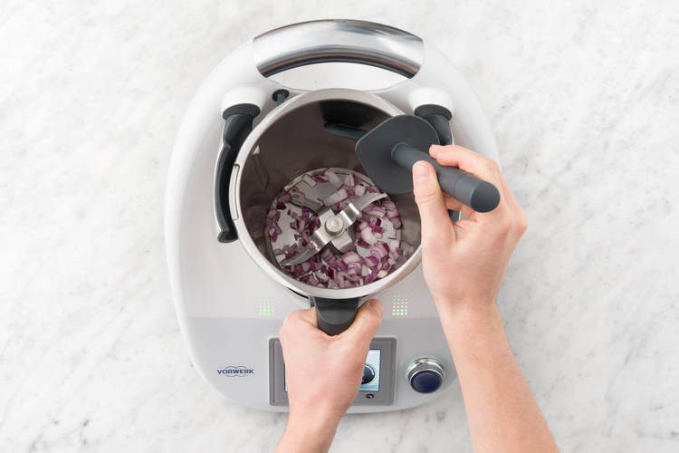 Zwiebelhälften und Knoblauch zerkleinern