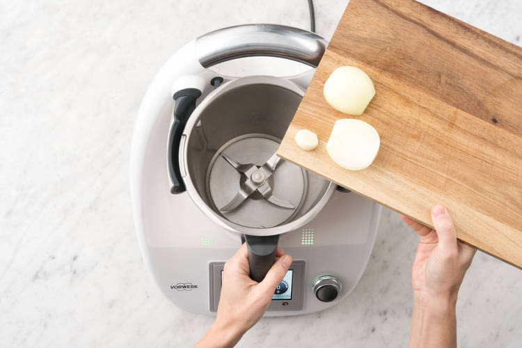 Zwiebelhälften und Knoblauch in den Mixtopf geben