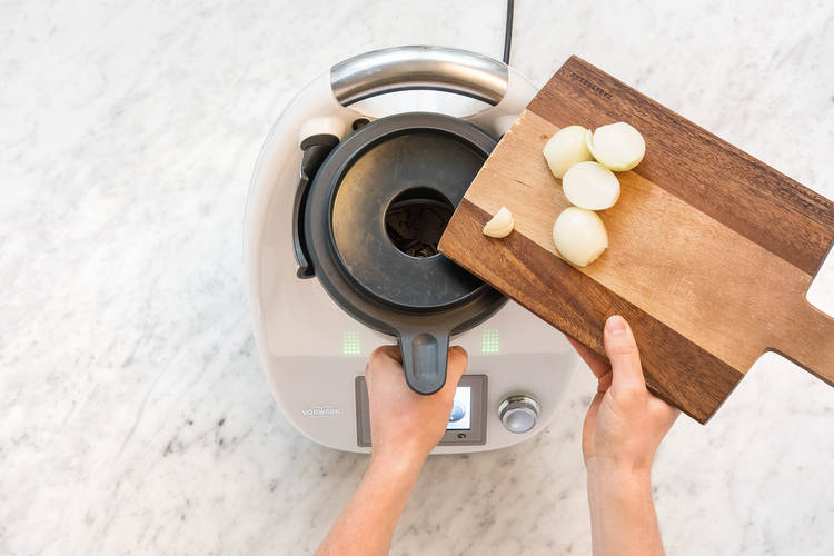 Zwiebelhälften und Knoblauch zugeben