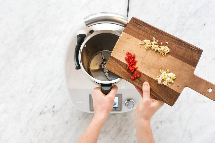 Ingwer, Chiliringe und weiße Frühlingszwiebelringe in den Mixtopf geben