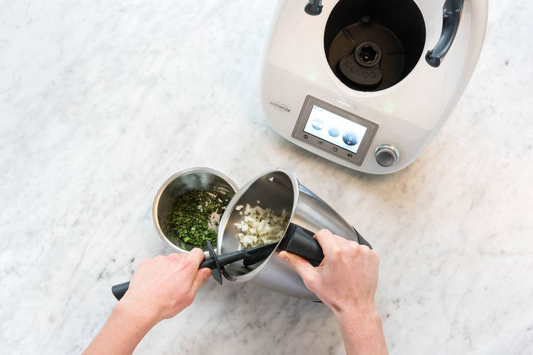 Zwiebeln und Knoblauch zum Koriander geben