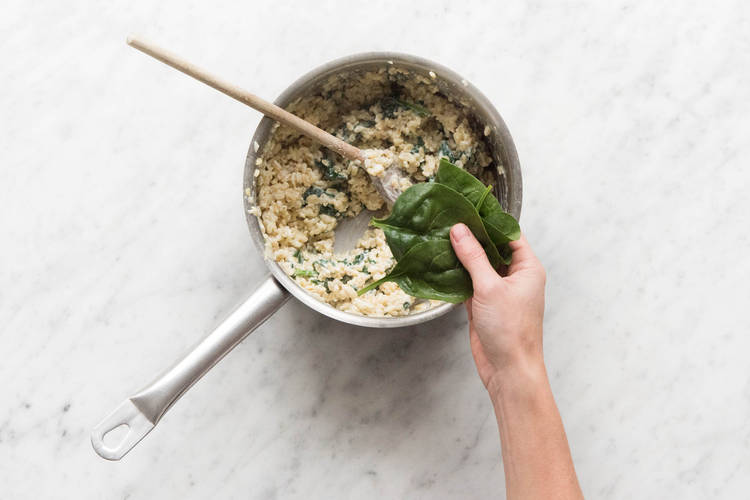 Spinat nach und nach unter das Risotto heben