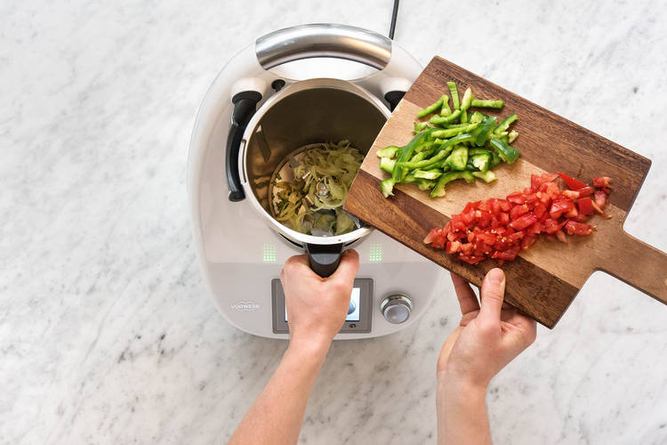 Paprikastreifen und Tomatenstücke in den Mixtopf geben