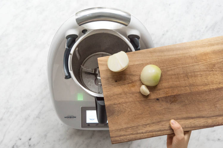 Zwiebelhälften und Knoblauch in den Mixtopf geben