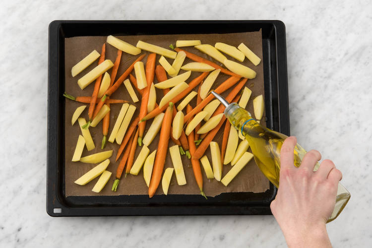 Verdeel de bospeen en aardappelen over een bakplaat met bakpapier
