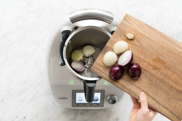 Zwiebelhälften und Knoblauch in den Mixtopf geben