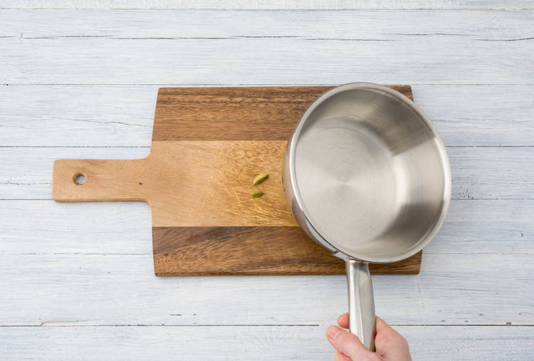 Kardamomkapsel mit einem Topfboden leicht andrücken