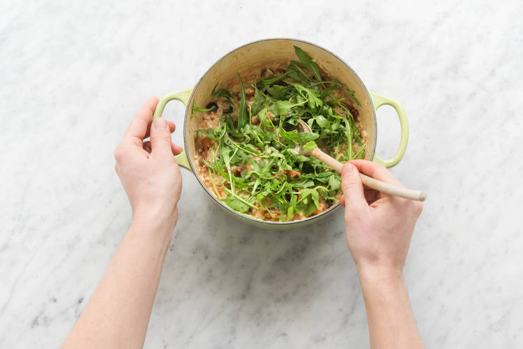 Rucola unter das Risotto rühren