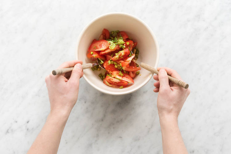 Pistazien unter den Tomatensalat heben