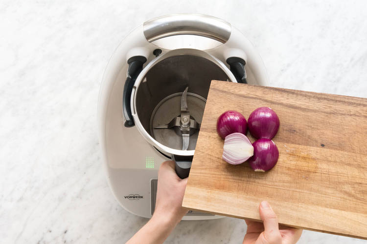 Rote Zwiebelhälften in den Mixtopf geben