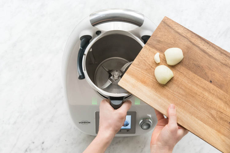 Zwiebelhälften und Knoblauch in den Mixtopf geben