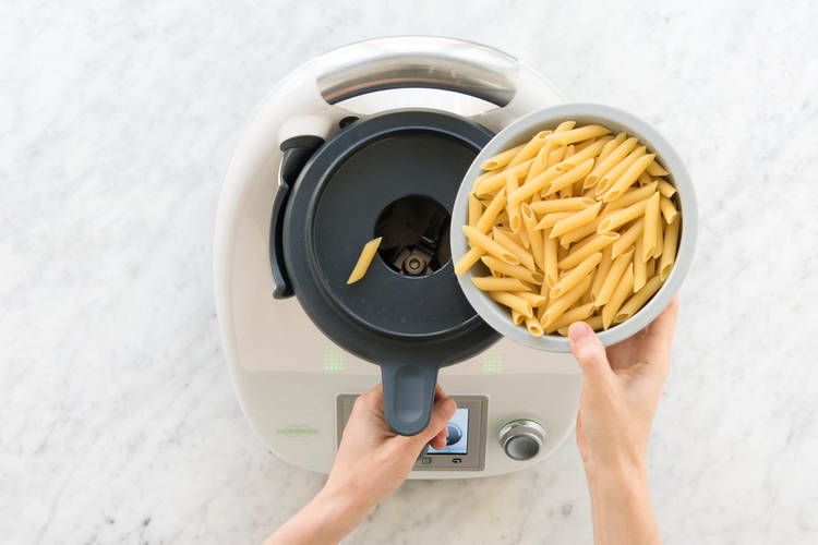 Penne durch die Deckelöffnung in den Mixtopf zugeben