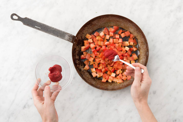 Voeg de tomatenpuree en harissa toe