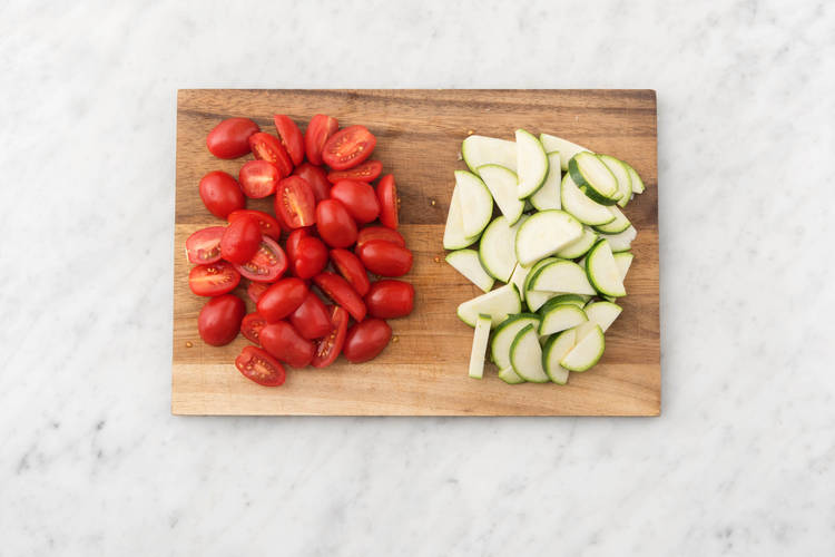 Snijd de courgette in halve plakken en halveer de mini-romatrostomaten