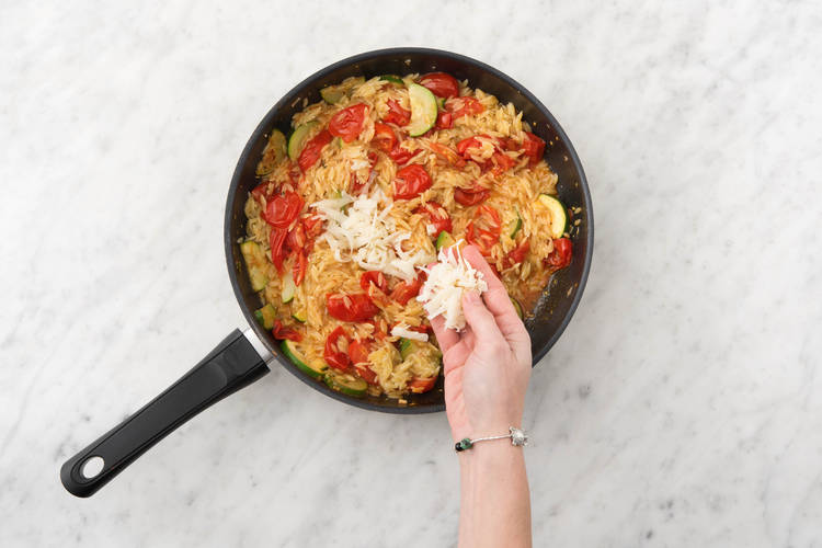 Voeg de helft van de gruyère en de groenten toe aan de orzo