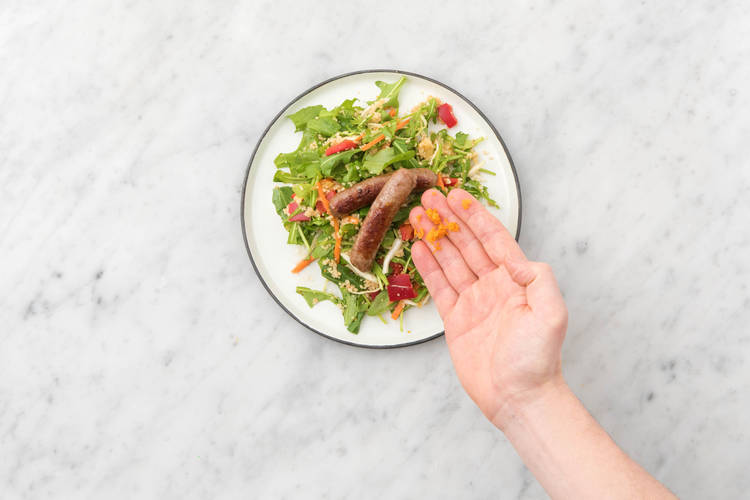 Garneer met extra sinaasappelrasp naar smaak en serveer met de kip-merguezworstjes