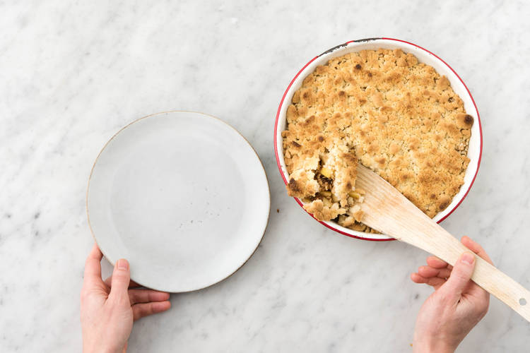 Apfel-Crumble auf Teller verteilen