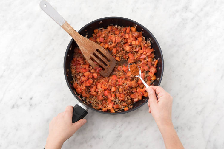 Voeg de paprika, tomaat, kaneel, komijn, paprikapoeder en tomatenpuree toe