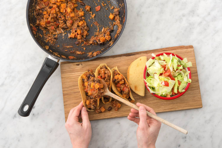 Vul de taco's met de saus en serveer met de friszoete ijsbergsalade.