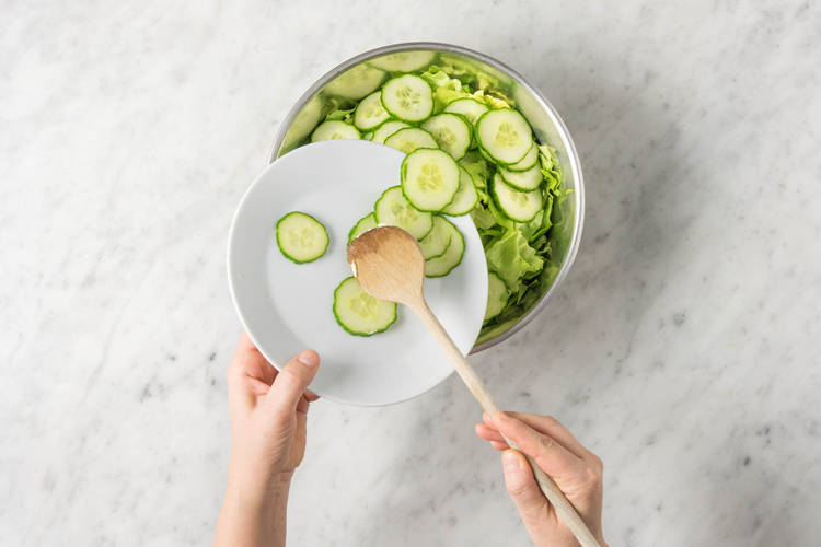 Gurken zum Salat geben